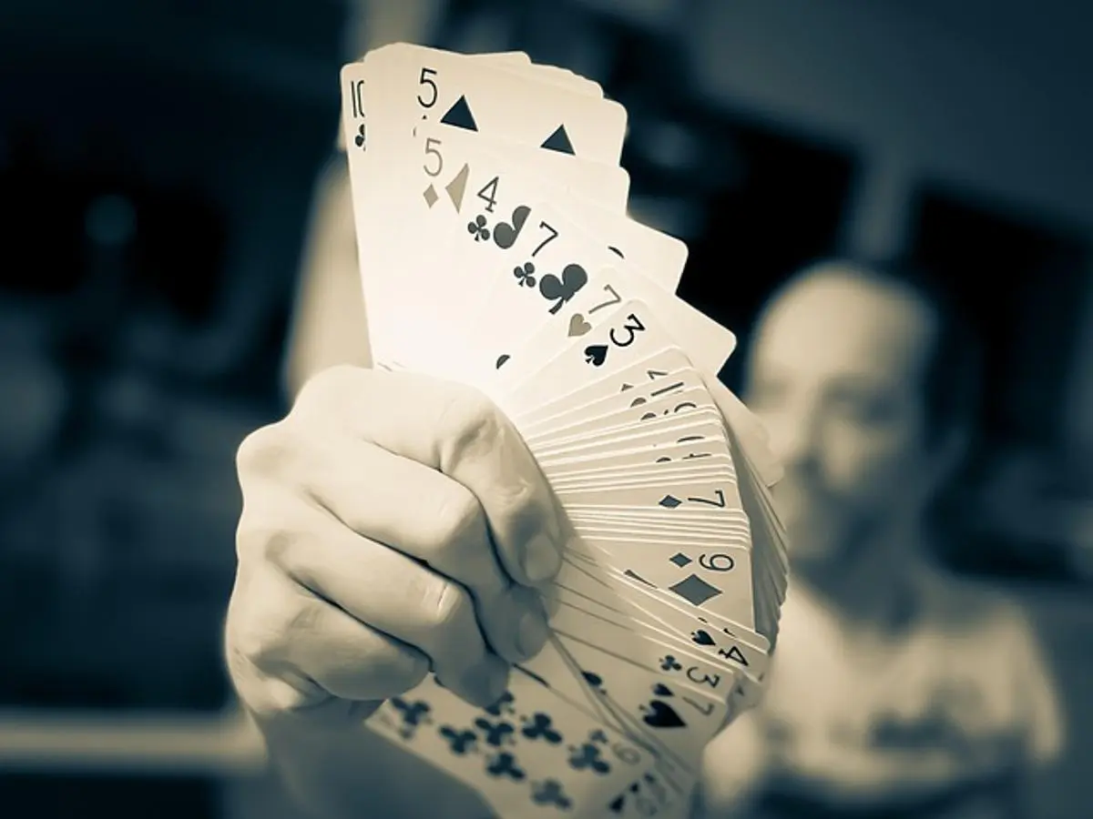 person-holding-playing-cards