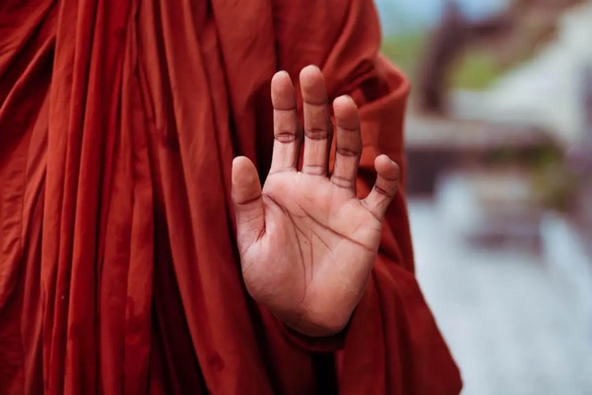 monk-holding-a-hand-up