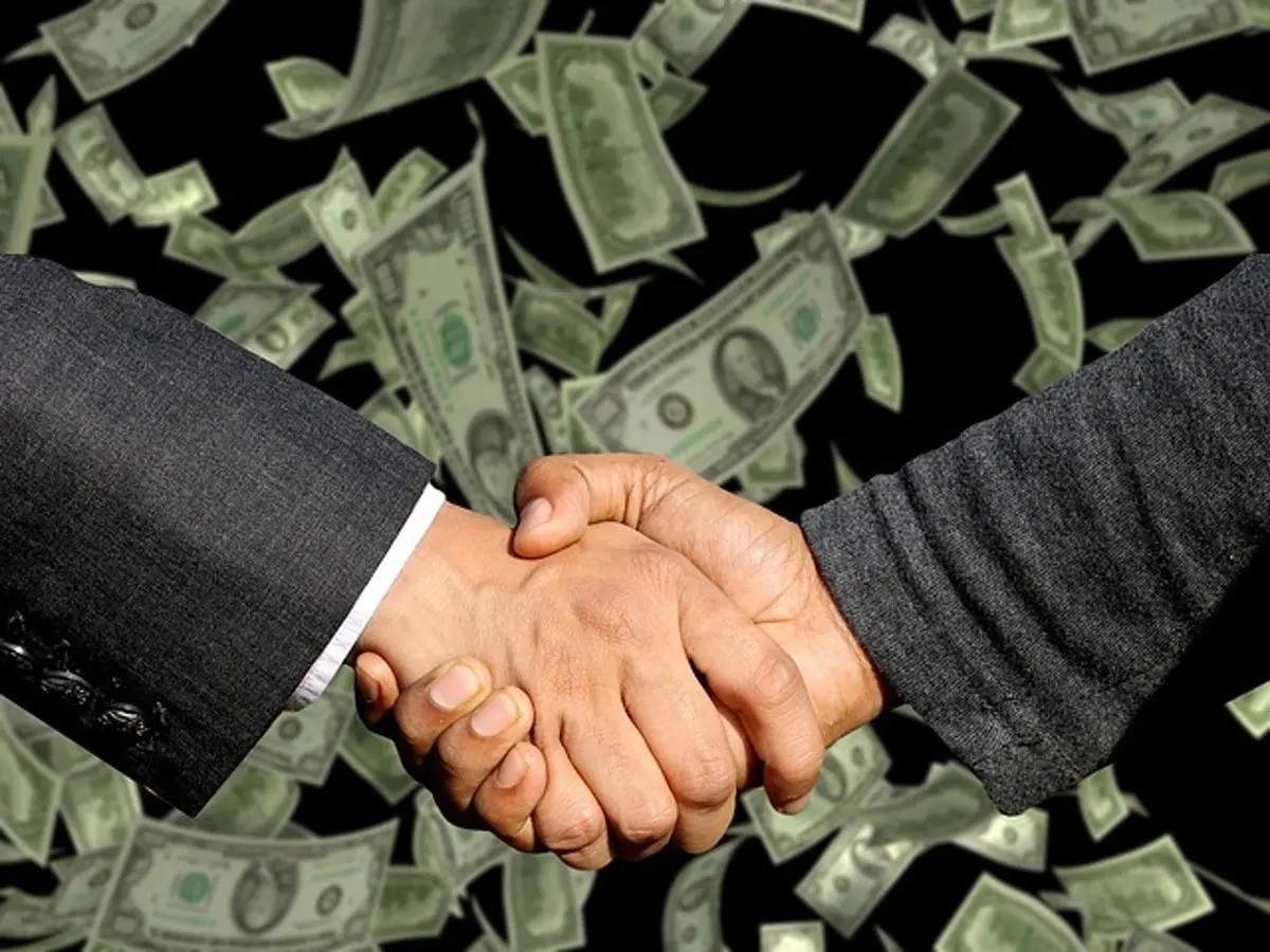 businessmen-shake-hands-money-falling-from-sky