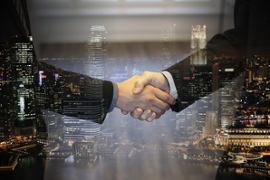 businessmen-shake-hands-cityscape-background