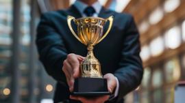 businessman-holding-trophy