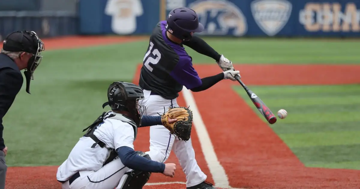 A baseball player batting away a ball.