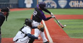 A baseball player batting away a ball.