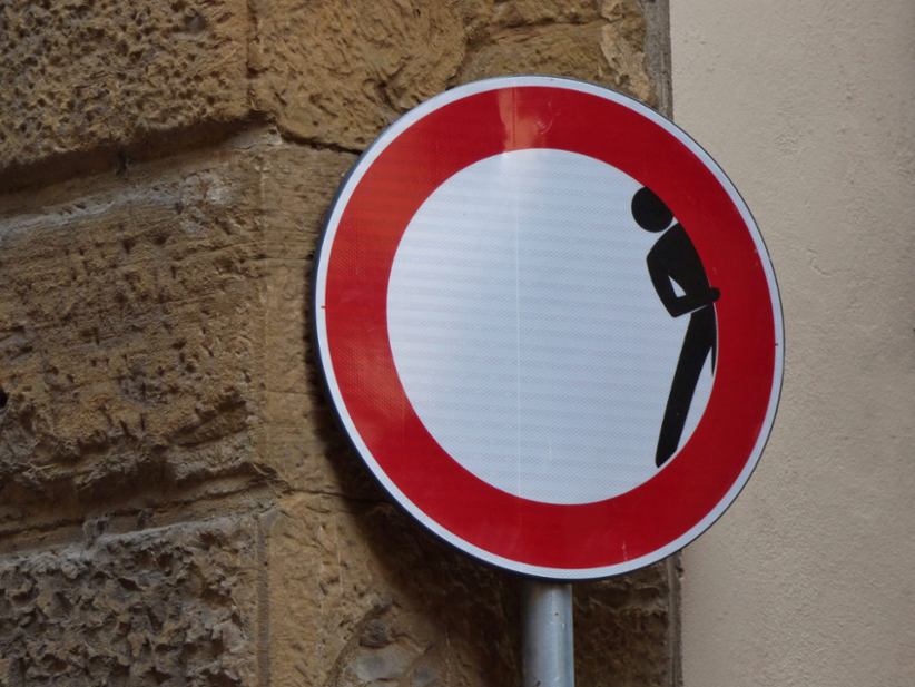 A prohibition road sign with a stick-man hiding.
