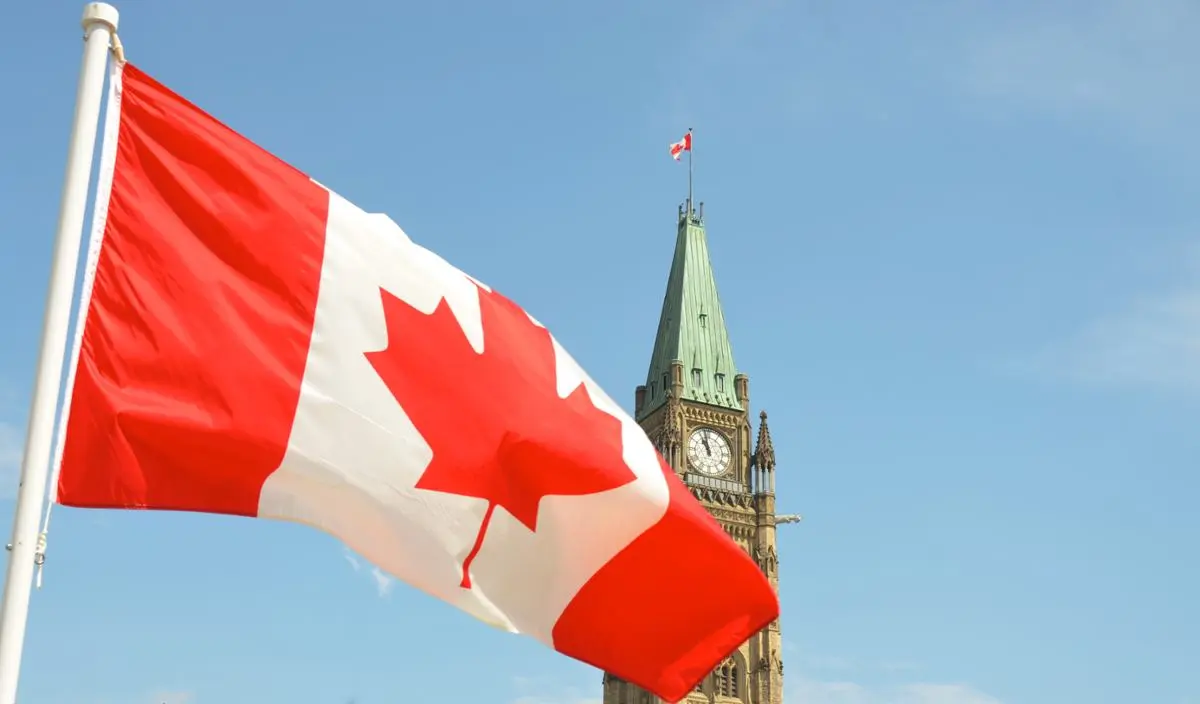 The Canadian flag against an urban background.