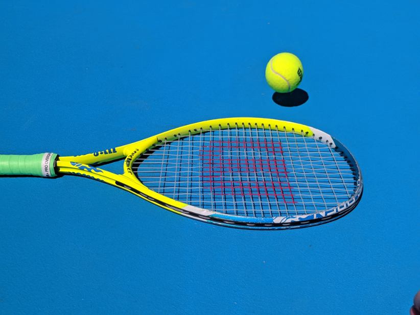 A tennis rocket lying on the field.