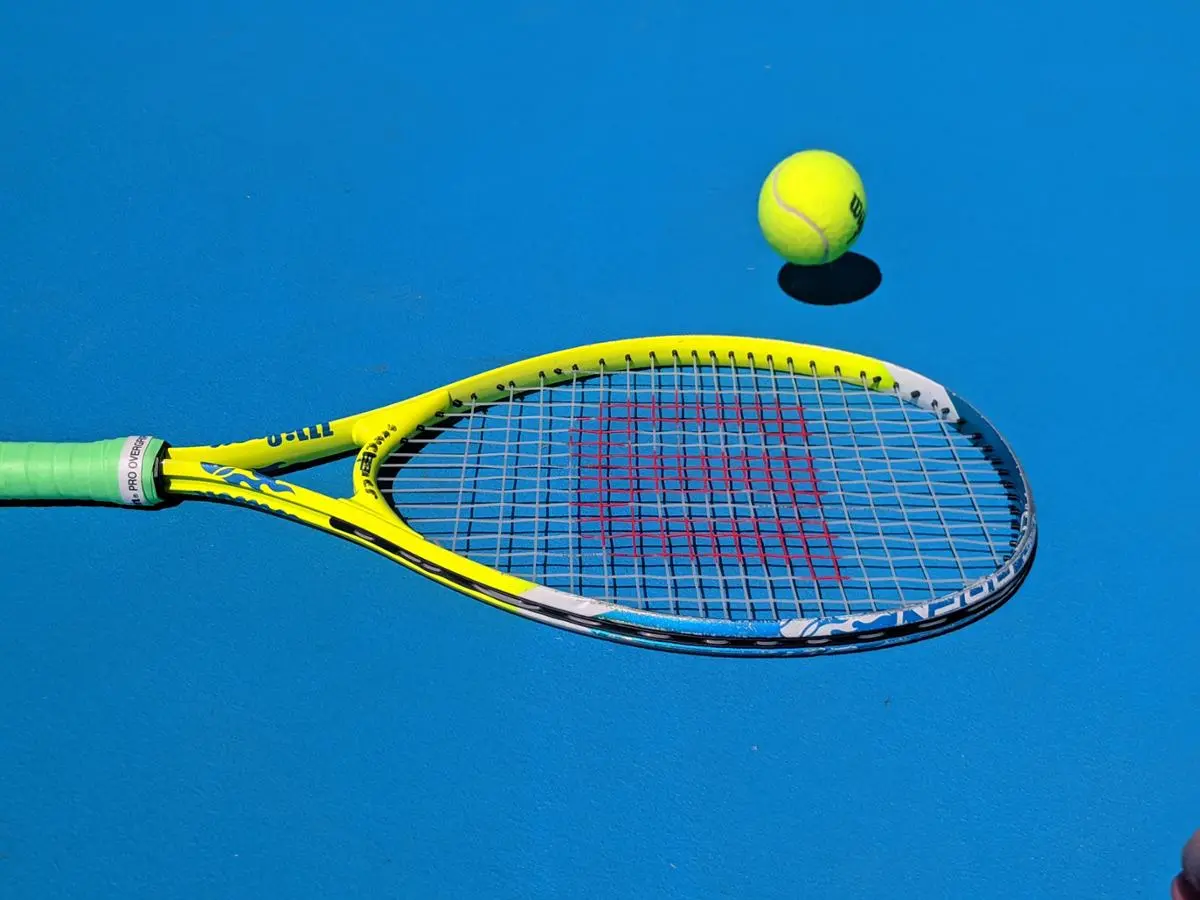 A tennis rocket lying on the field.