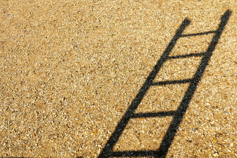 A shadow of a ladder in the sand.