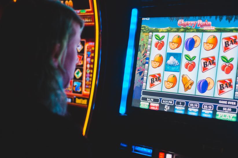 A person sitting at a slot machine.