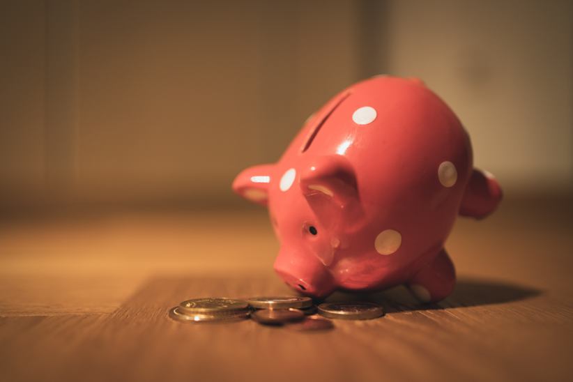 A piggy bank looking at coins.