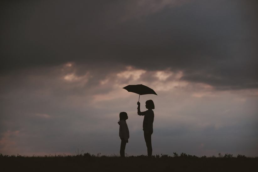 Two kids holding umbrella.