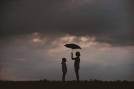 Two kids holding umbrella.