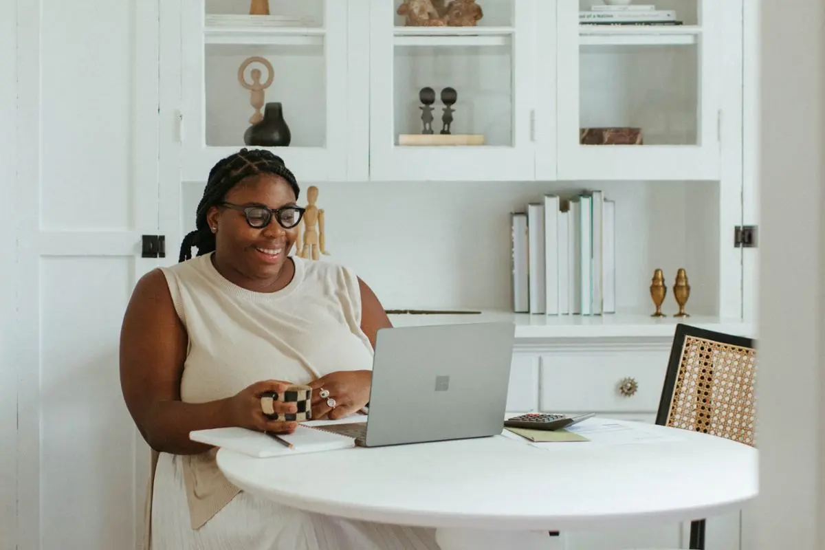 A woman sitting at a laptop and smiling