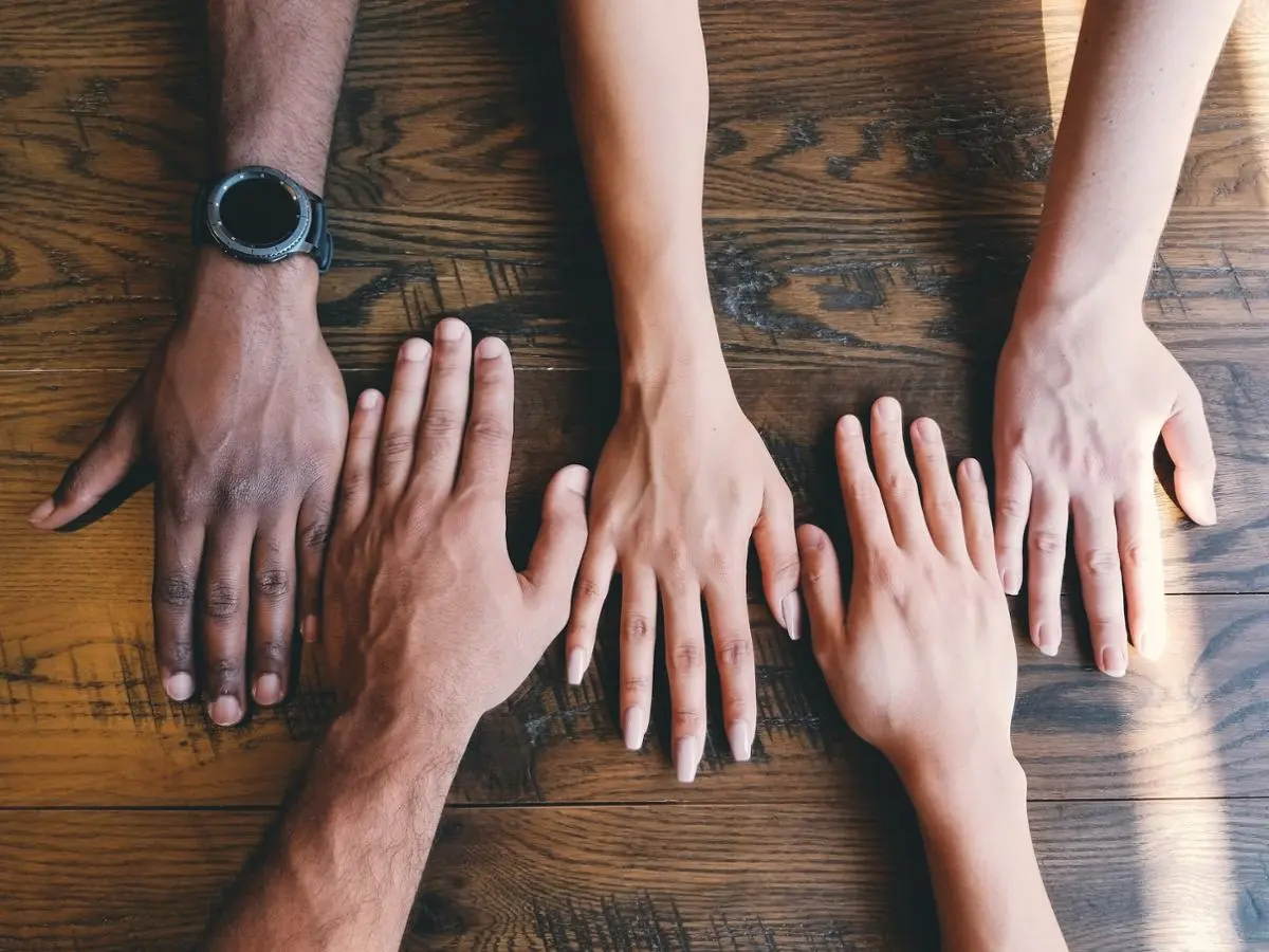 five-human-hands-of-different-color-on-a-table