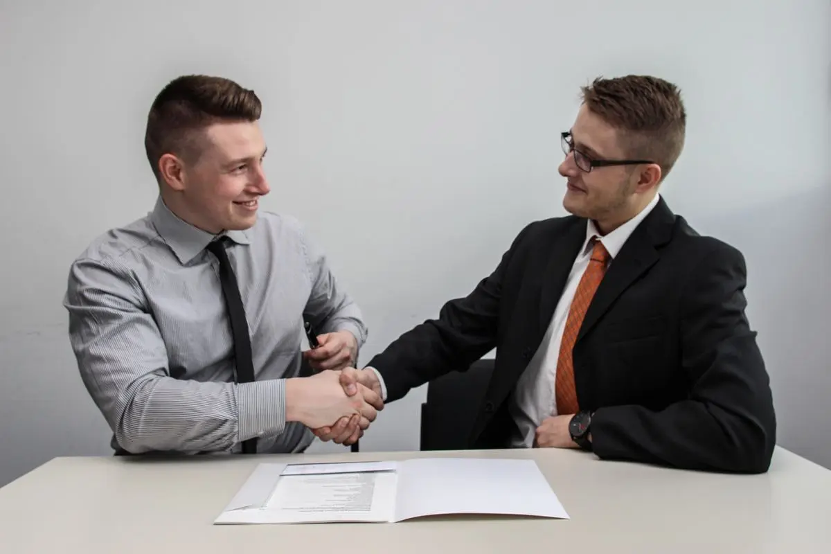 Two men shaking hands over a completed deal.