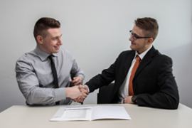 Two men shaking hands over a completed deal.