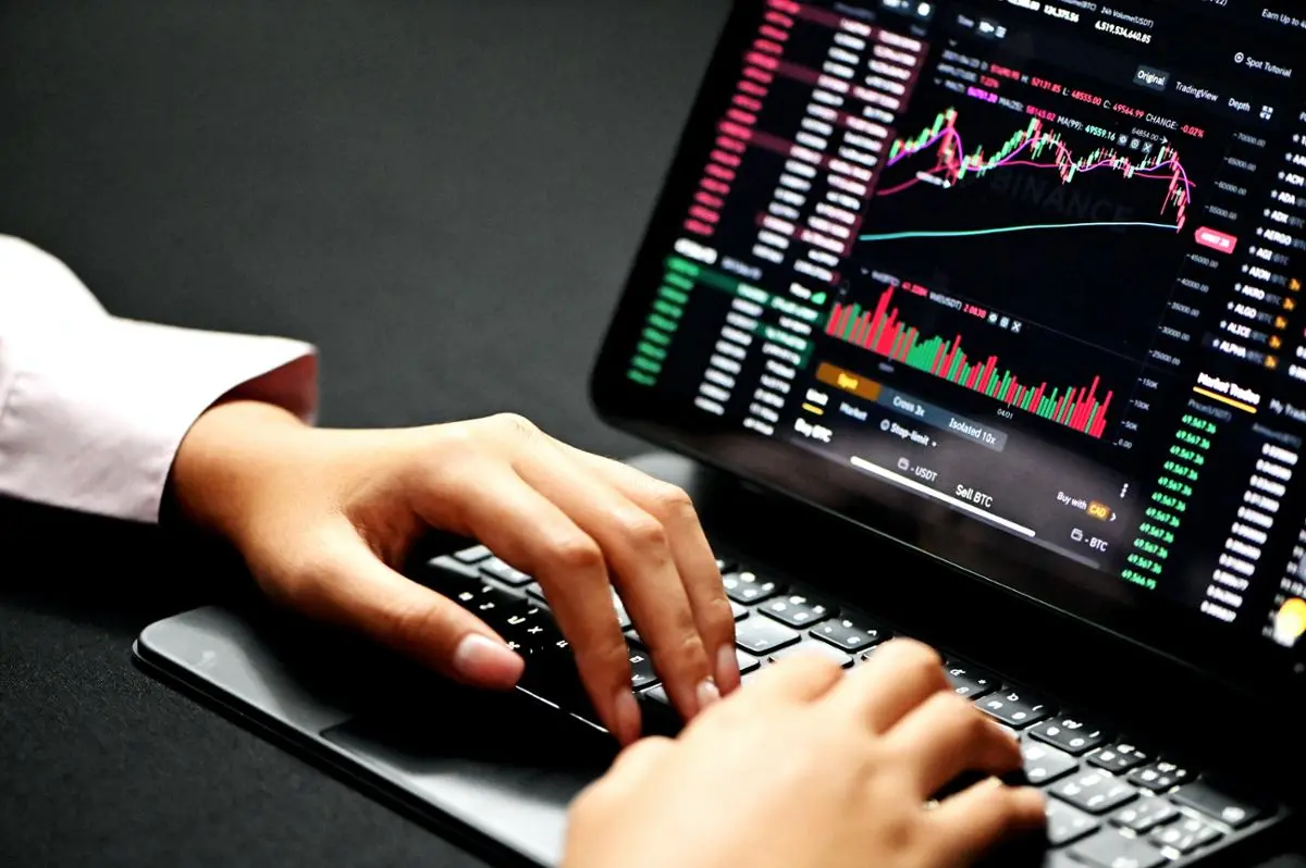 A person trading behind a computer.