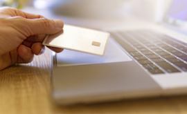 Close-up-photo-man-holding-credit-card-over-a-laptop