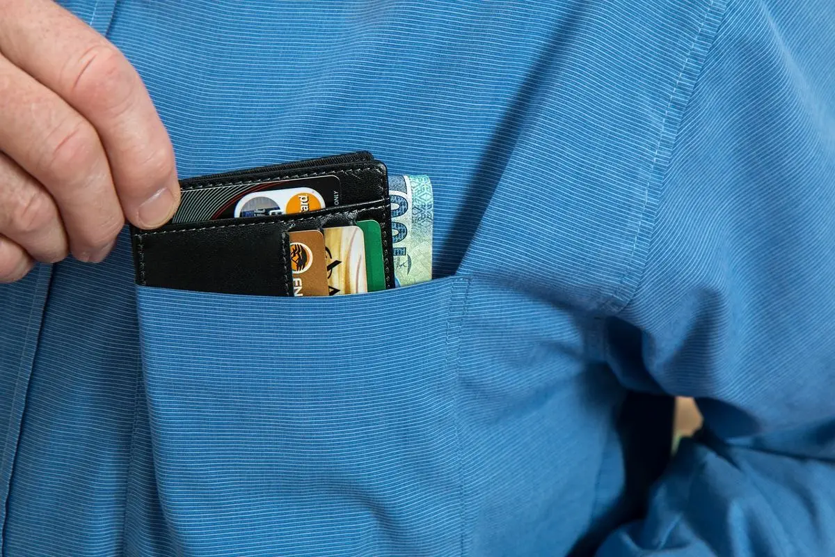 man-reaching-for-wallet-with-cards-in-shirt-pocket