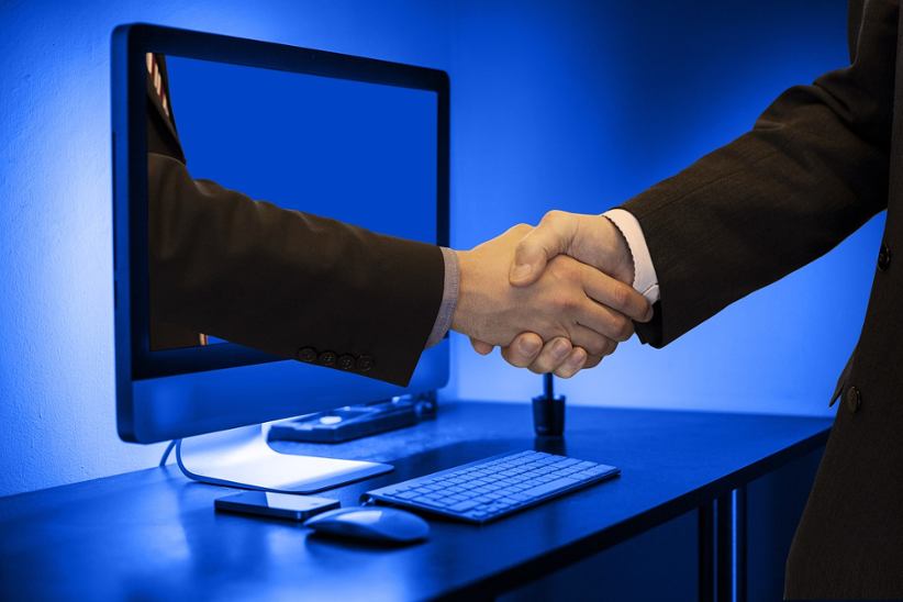 businessman-shaking-hand-with-another-businessman-through-a-monitor