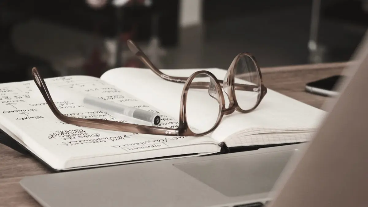 A notebook with glasses on top.