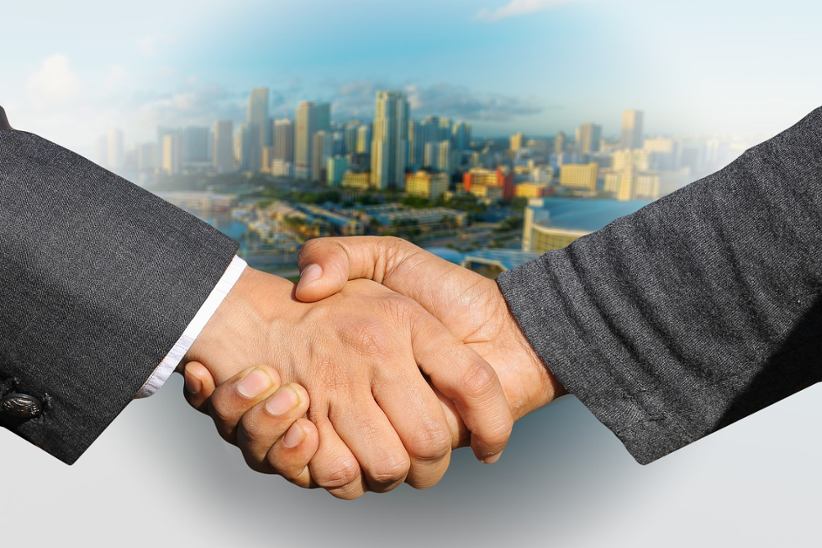 two-businessmen-shaking-hands-on-a-cityscape-background