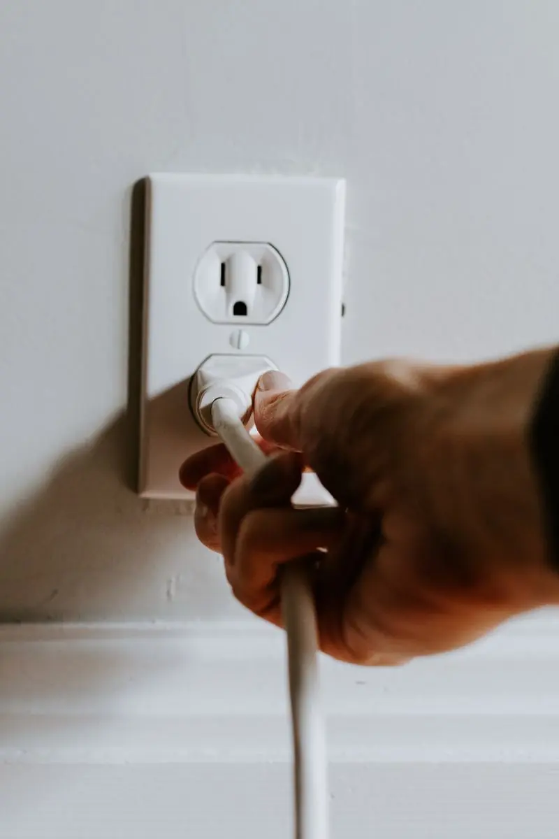 A person unplugging a cable.