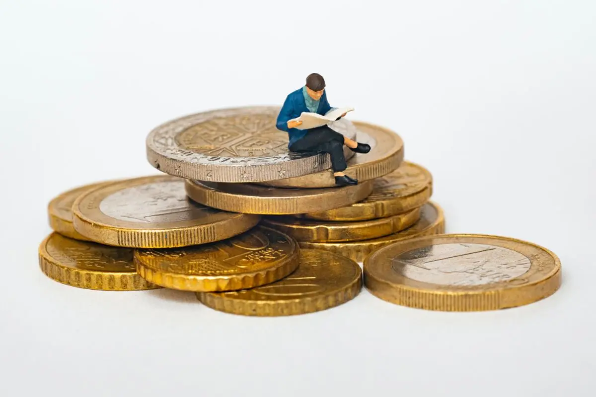 A person sitting on top of a mountain of coins.