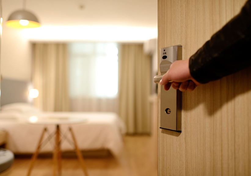 man-holding-hotel-door-open