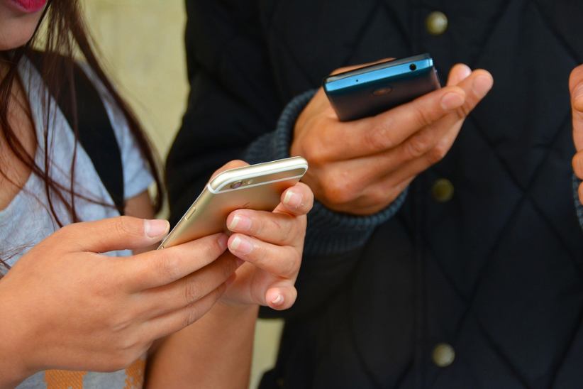 man-and-woman-holding-smartphones