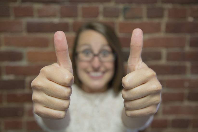 woman-making-thumb-up-gesture-with-both-hands