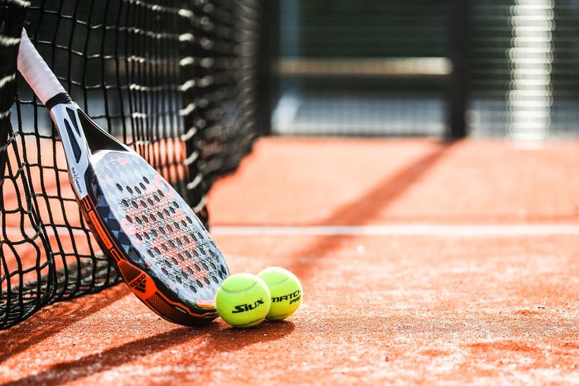 tennis-racket-and-tennis-balls-on-field