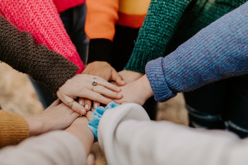A group of people joining hands.