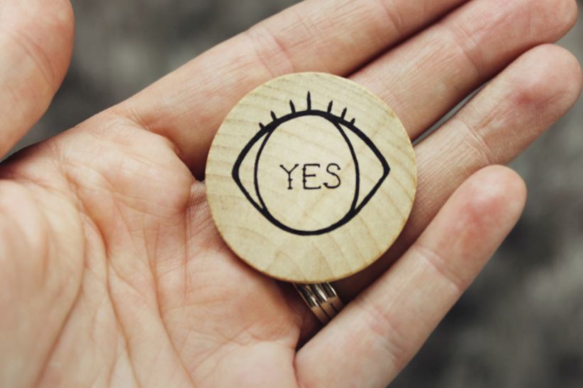 A Yes token in a palm of the hand.
