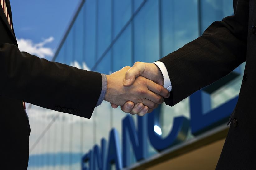 two-businessmen-shake-hands-financial-deal