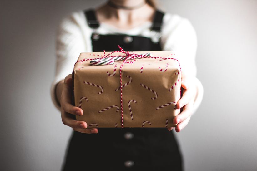 A person giving over a gift box.