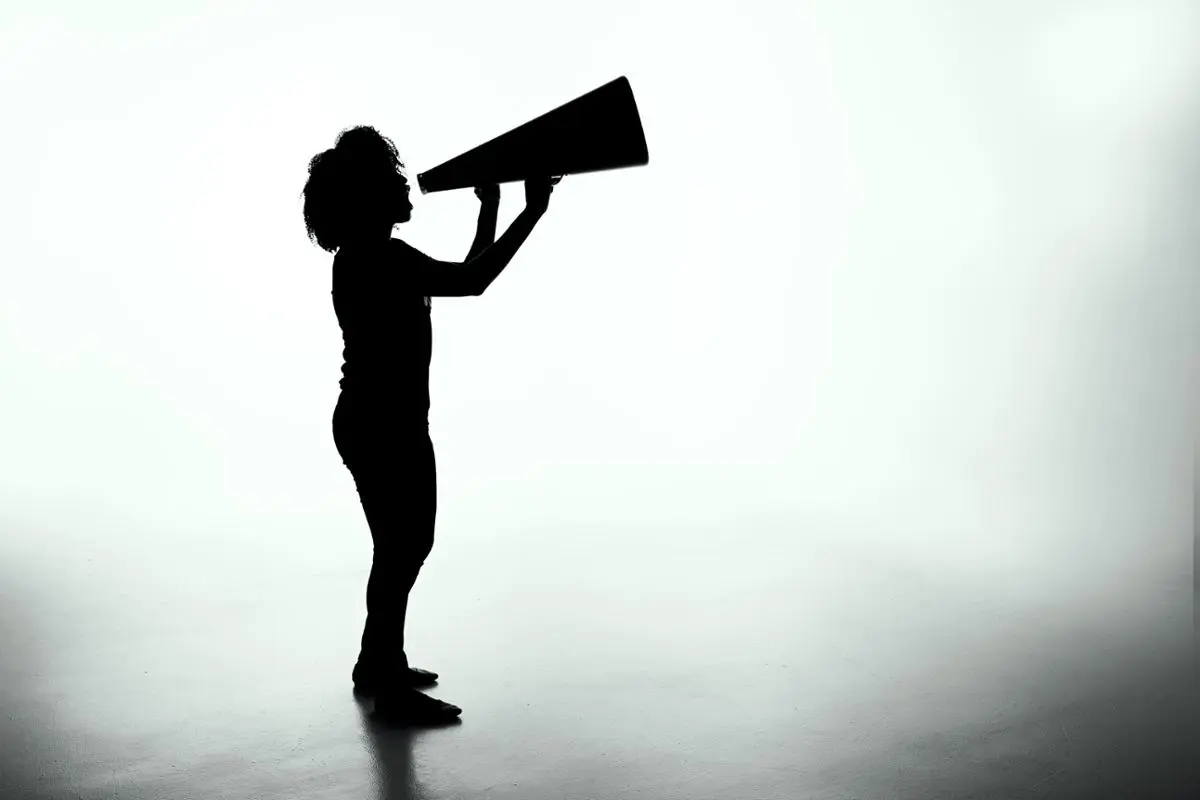 A woman holding a big megaphone.