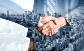two-businessmen-shake-hands-cityscape-background
