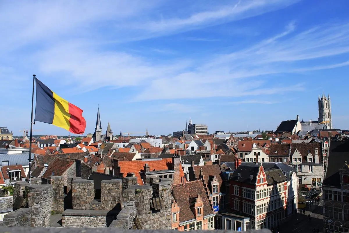 belgium-flag-on-a-pole-cityscape-background