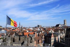 belgium-flag-on-a-pole-cityscape-background