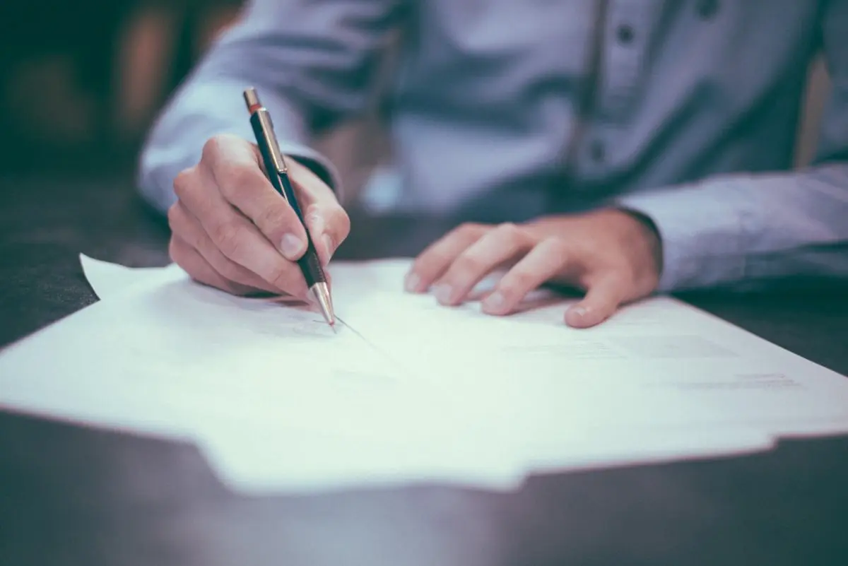 A person signing a document.