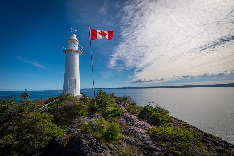 a-lighthouse-and-canadian-flag-on-a-pole