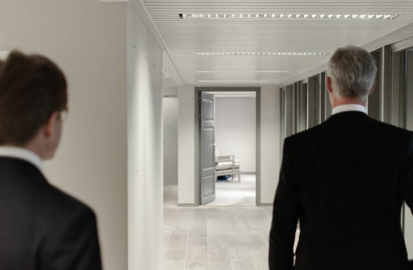 two-businessmen-walking-down-hallway