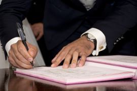 a-close-up-photo-of-a-man-signing-a-document