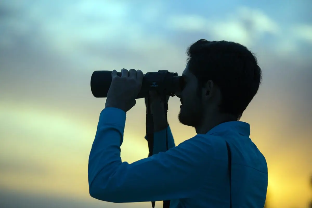 man-looking-through-binoculars