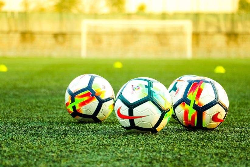 three-soccer-balls-on-field