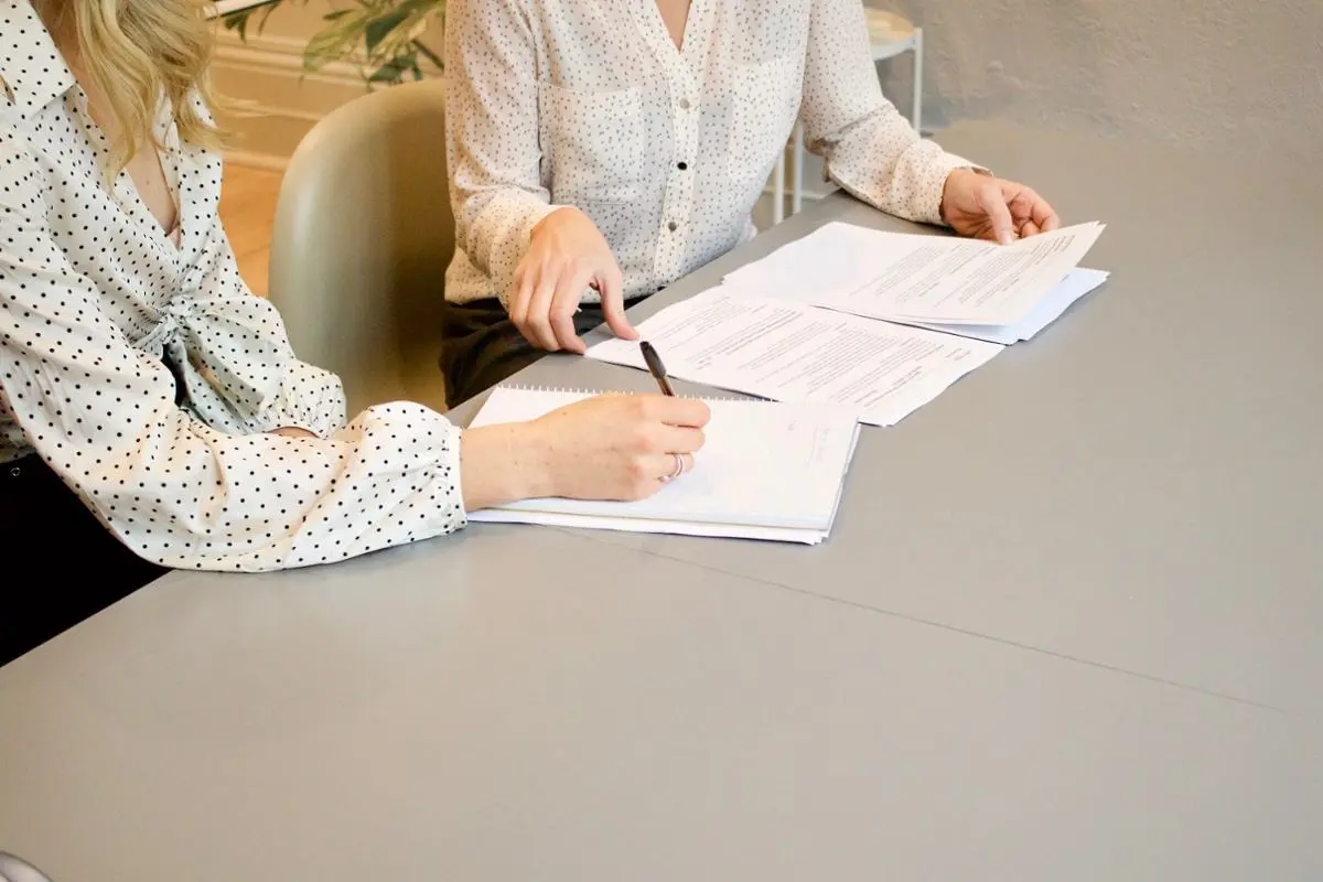 Two people signing something.