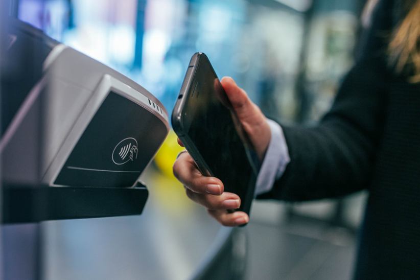 woman-holding-smartphone-to-pay-cashless