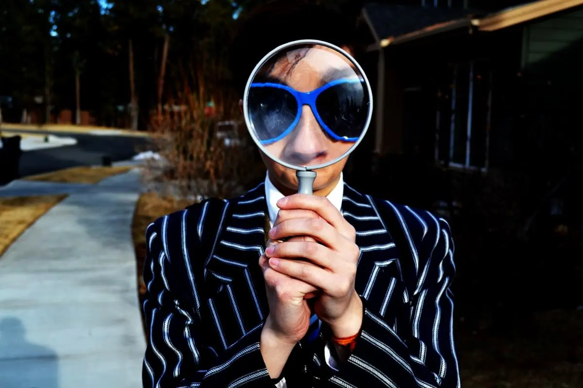 A person looking through a mangnifying glass.