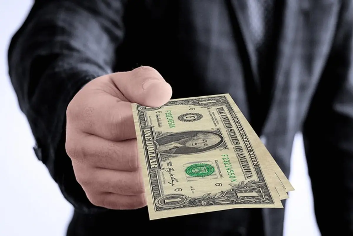 businessman-giving-one-dollar